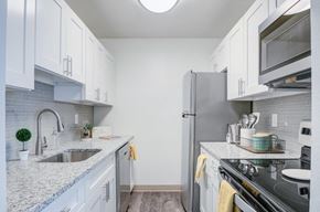 South Park apartment for rent - A kitchen with white cabinets and a black stove top oven.