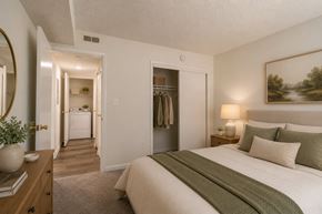 Greenville apartment for rent - A bedroom with a large bed and a painting on the wall.
