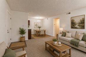 Greenville apartment for rent - A living room with a couch, coffee table, and a dining table.