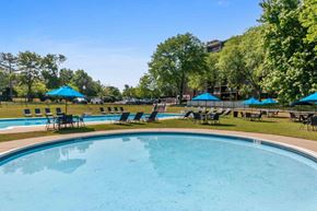 East Norriton apartment for rent - a swimming pool with blue umbrellas and chairs around it