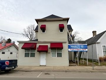 New Albany apartment for rent - A building with a red awning and a blue sign in front of it.