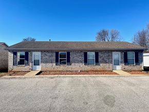 Corydon apartment for rent - a brick house with blue shutters and a driveway