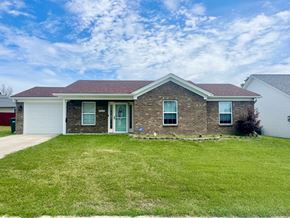 Louisville house for rent - a brick house with a green lawn and a blue sky