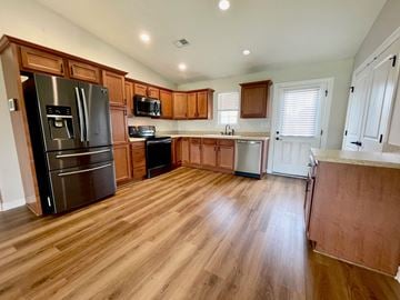 Louisville house for rent - a kitchen with wooden floors and stainless steel appliances