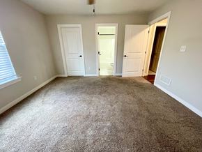 Louisville house for rent - an empty living room with carpeting and white doors