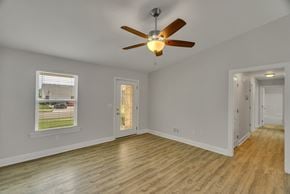 Louisville house for rent - a living room with wood floors and a ceiling fan
