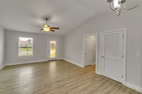 Louisville house for rent - an empty living room with a ceiling fan and a door to a closet