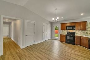 Louisville house for rent - the kitchen and living room of a house with wood flooring and