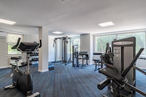 Baltimore apartment for rent - A gym with a variety of equipment including a treadmill, weights, and a bench press.