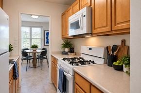 Baltimore apartment for rent - A kitchen with a white stove and wooden cabinets.