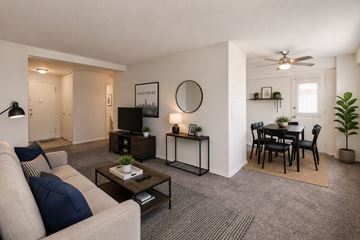 Baltimore apartment for rent - A living room with a grey carpet and a white ceiling fan.