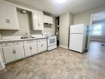 Louisville house for rent - an empty kitchen with white appliances and white cabinets