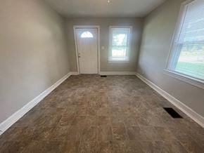 Louisville house for rent - an empty room with tile flooring and a white door
