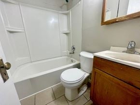 Louisville house for rent - a bathroom with a toilet and a tub and a sink