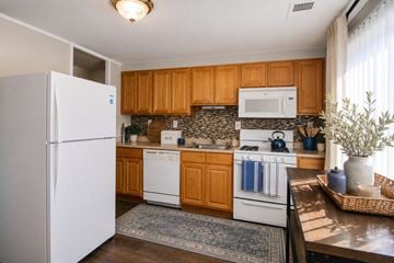 Baltimore townhouse for rent - A kitchen with wooden cabinets and white appliances.