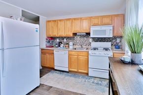 Baltimore townhouse for rent - a kitchen with white appliances and wooden cabinets