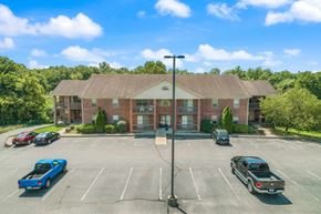 Salem apartment for rent - an empty parking lot in front of a brick building with cars parked in front