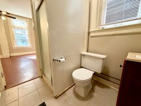 Louisville apartment for rent - A white toilet in a bathroom with a glass shower door.