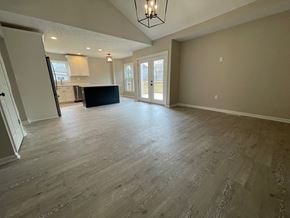 Louisville house for rent - A spacious room with wooden flooring and a black countertop.