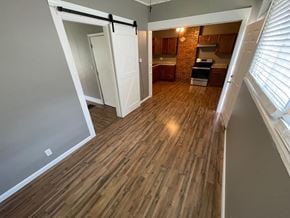 Jeffersonville apartment for rent - an empty living room with wood flooring and a door to a kitchen