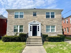 Louisville apartment for rent - A grey stone house with a white door and windows.