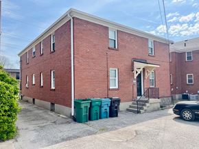 Louisville apartment for rent - A red brick building with a black car parked in front.