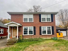 Louisville apartment for rent - A red brick house with a white door and black shutters.