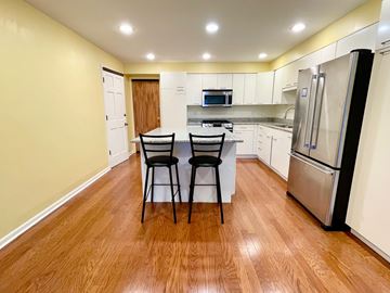 Louisville apartment for rent - A kitchen with a table and chairs in the middle.