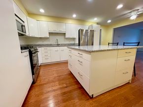 Louisville apartment for rent - A kitchen with white cabinets and a wooden floor.