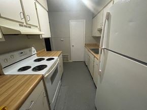 Louisville apartment for rent - A kitchen with white appliances and wooden countertops.