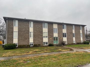Louisville apartment for rent - A building with a green door and windows on the ground floor.