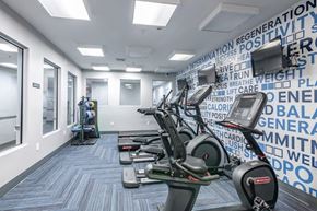 Cranford apartment for rent - a gym with cardio machines and a wall covered in words