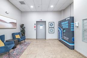 Cranford apartment for rent - the lobby of a building with a vending machine and chairs