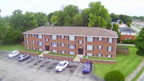 Louisville apartment for rent - A parking lot in front of a red brick building.