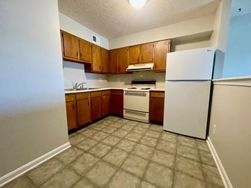 Shepherdsville apartment for rent - an empty kitchen with white appliances and wooden cabinets
