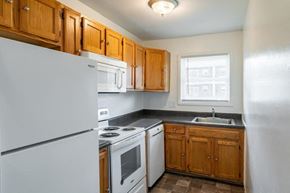 Long Branch apartment for rent - a kitchen with white appliances and wooden cabinets