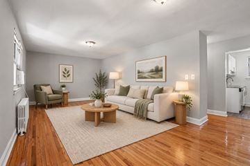 Elmwood Park townhouse for rent - A living room with a white couch, a coffee table, and a painting on the wall.