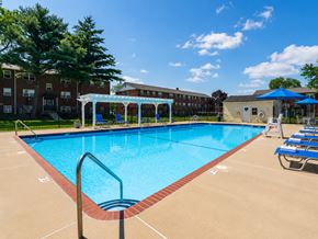 Bellmawr apartment for rent - A large swimming pool with a red brick border and a metal ladder.