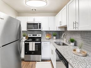 Bellmawr apartment for rent - A modern kitchen with a stainless steel refrigerator and black oven.