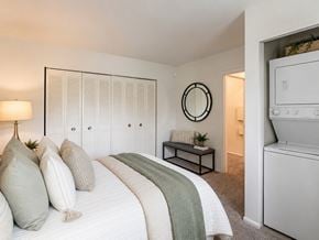 Bellmawr apartment for rent - A bedroom with a large bed and a white washing machine in the corner.