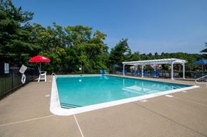 Middletown apartment for rent - a swimming pool with a red umbrella and chairs around it