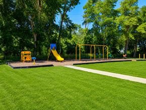 Eatontown apartment for rent - A playground with a yellow slide and a blue sign.