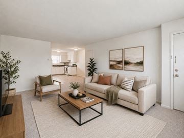 Eatontown apartment for rent - A living room with a white couch, a wooden coffee table, and a painting on the wall.