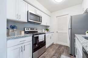 Absecon apartment for rent - A kitchen with white cabinets and a black refrigerator.