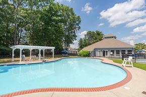 Absecon apartment for rent - A pool with a red border and a white pavilion.