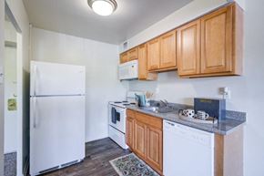 Cherry Hill apartment for rent - a kitchen with white appliances and wooden cabinets