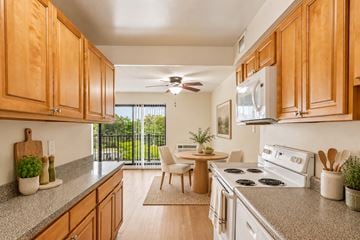 Cherry Hill apartment for rent - A kitchen with wooden cabinets and a white stove top oven.