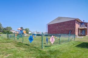 Wilmington apartment for rent - the playground is behind a chain link fence with flags on it