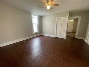 New Albany apartment for rent - A room with a ceiling fan and wooden flooring.