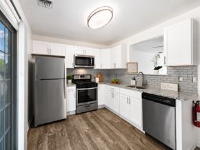 Annandale townhouse for rent - A modern kitchen with white cabinets and stainless steel appliances.